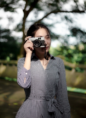 手持相机拍照的千鸟格美女图片